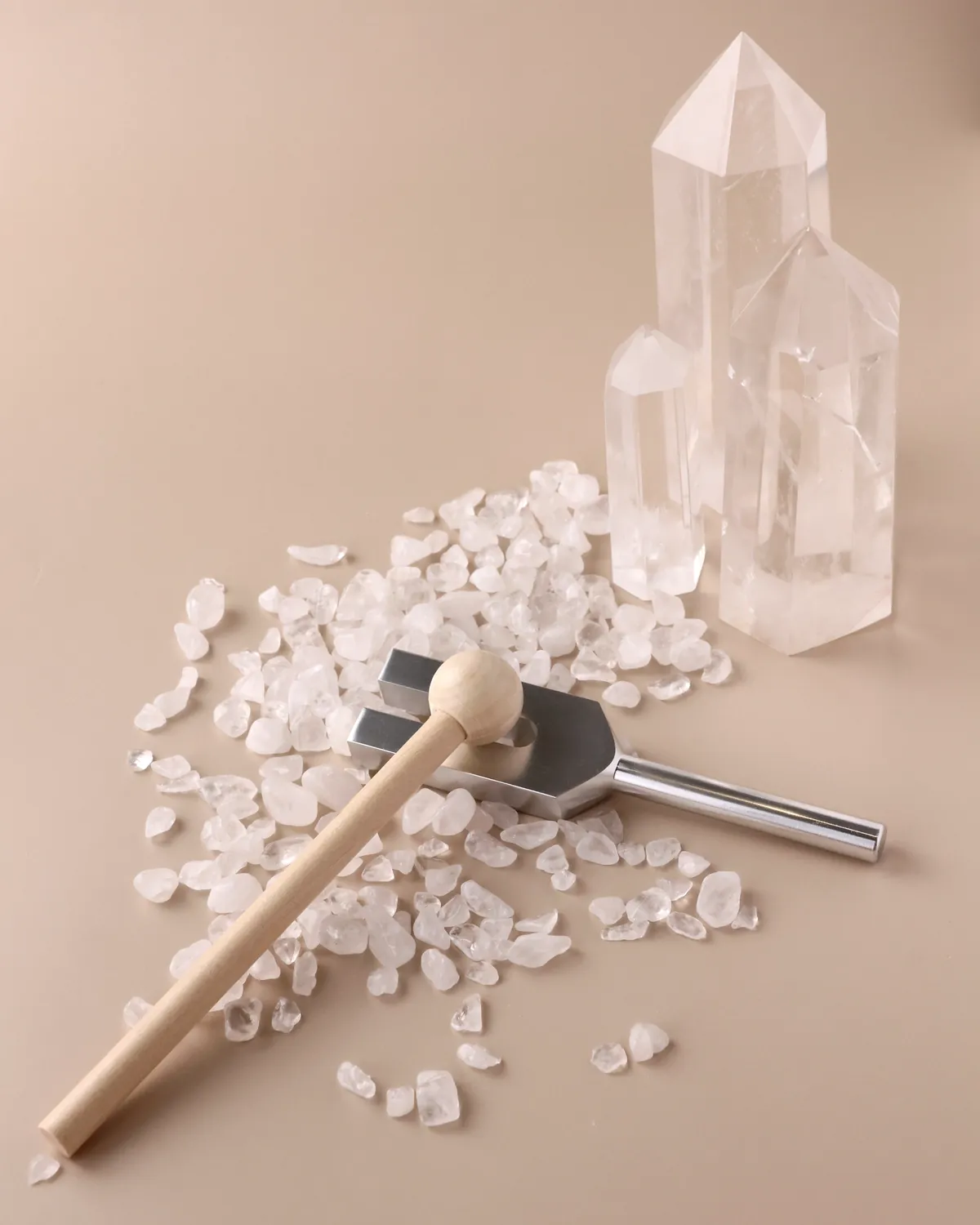 Clear quartz points and quartz chips with a small wooden mallet