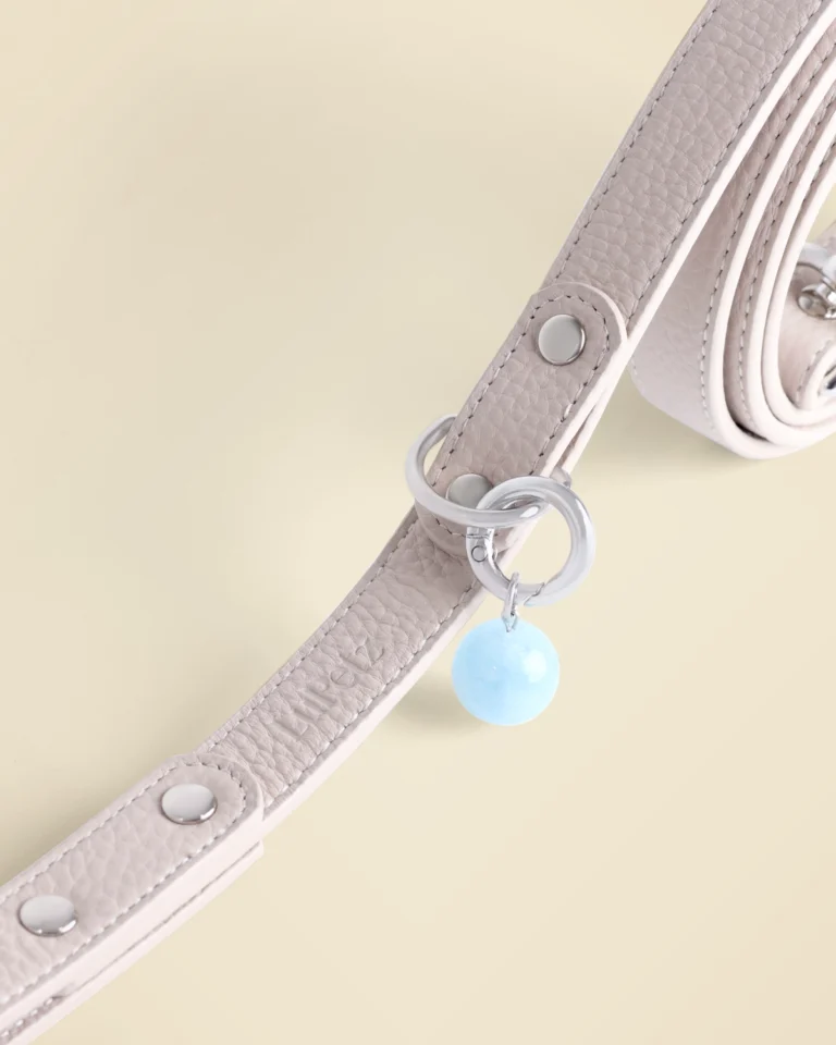 Close-up of a taupe leather LuKra leash with an aquamarine bead by the clip