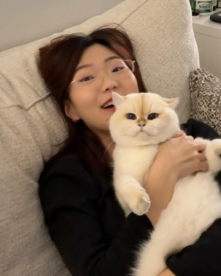 Cat owner bonding with her cat wearing an aquamarine collar